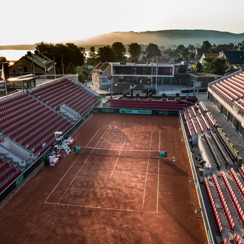 Tennisbana i båstad med solnedgång och tom läktare.