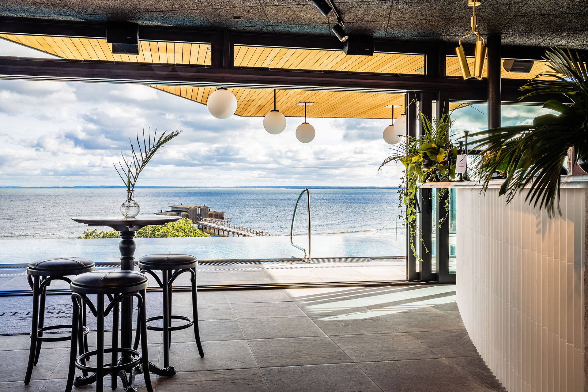 Bar och lounge i rooftop spa med hav i bakgrunden.