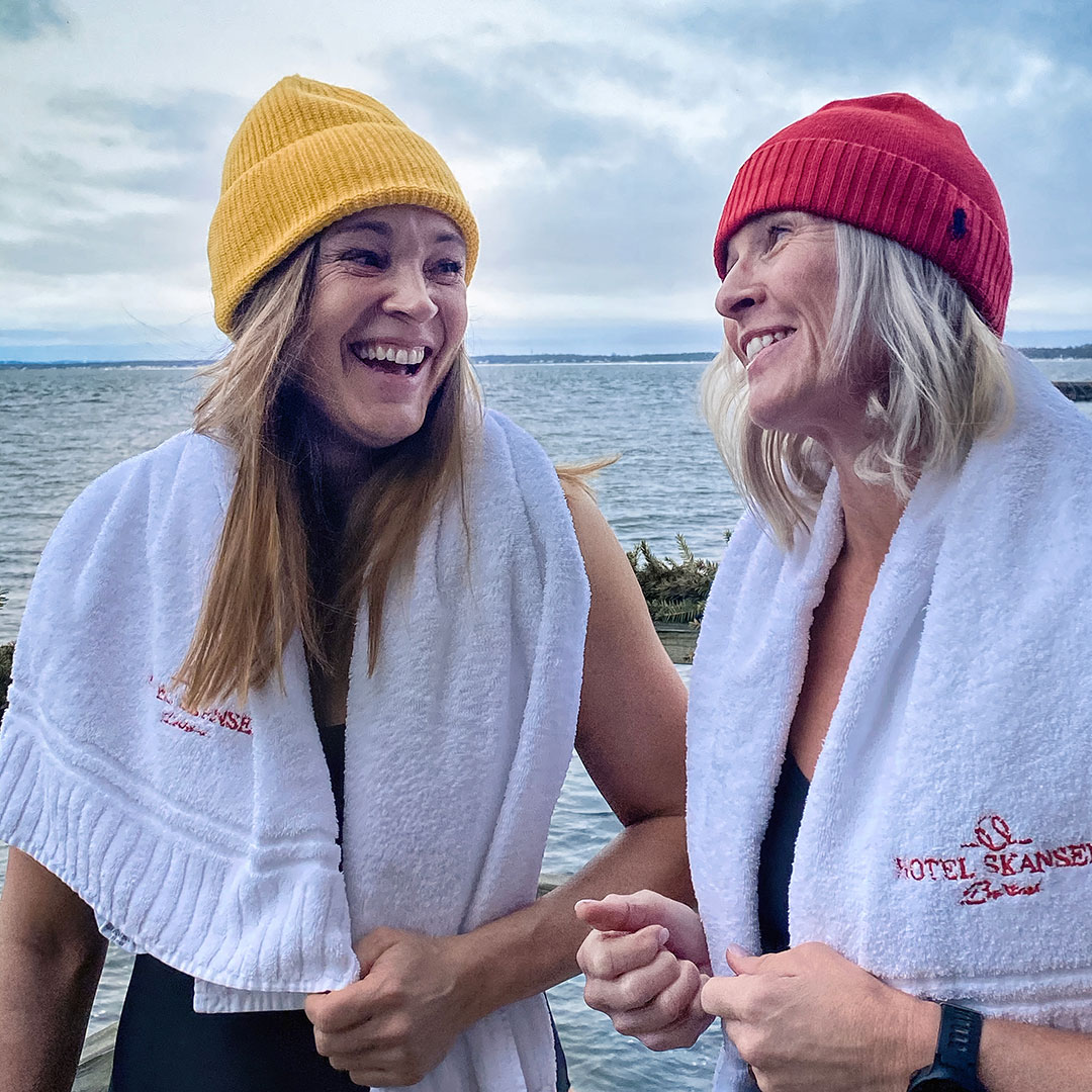 Vinterbadarer med färgglada mössor skrattar och ler mot varandra